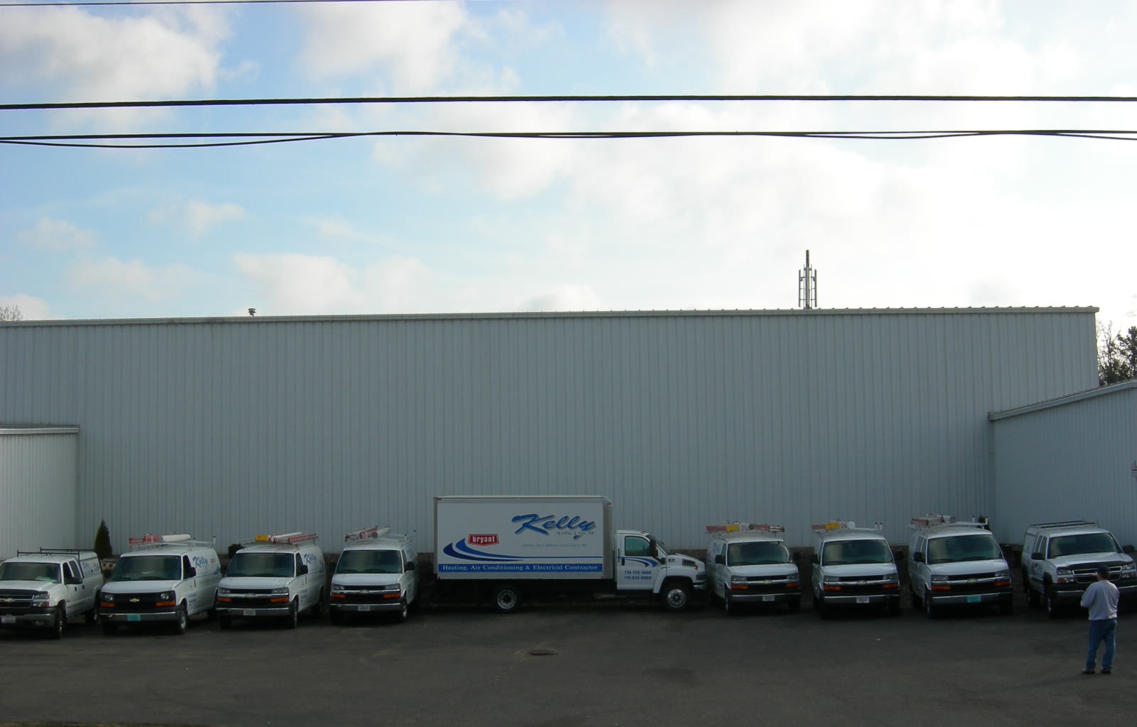 Kelly Heating & Electric fleet of vans and trucks outside the shop